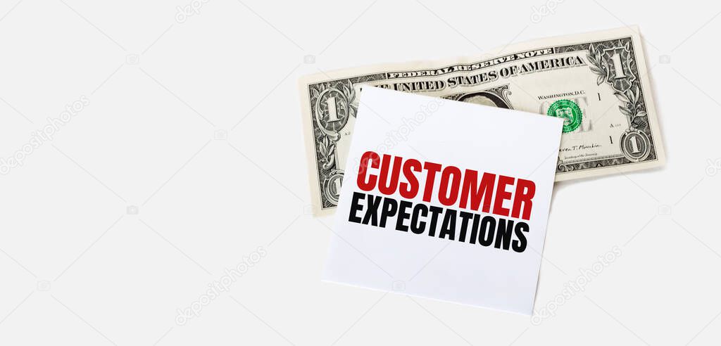 1 dollar bill and white notepad sheet on the white background. Customer Expectations text