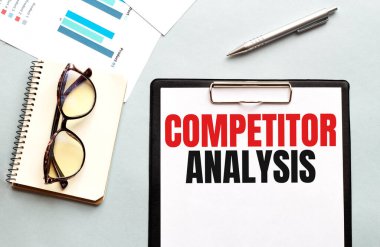 İş konsepti. Not defteri beyaz arkaplanda gözlük ve notlar için COMPETITOR ANALYSIS sayfası