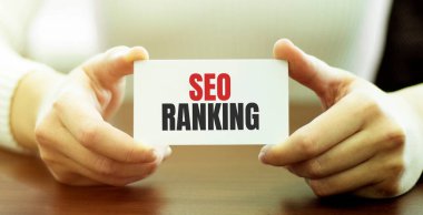 İş kadını elinde SEO RANking yazılı bir kart tutuyor.