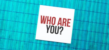 Mavi ahşap zemin üzerinde Who Are You yazan boş not defteri