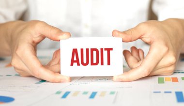 İş kadını elinde AUDIT yazılı bir kart tutuyor