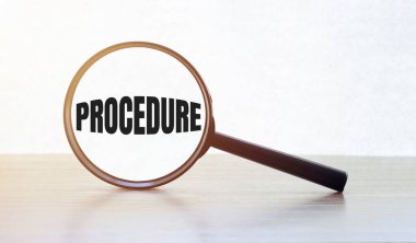 Tahta masa üzerinde metin proCEDURE ile büyüteç.
