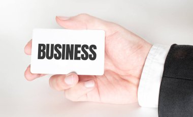 İş adamı elinde metin işiyle bir kart tutuyor.