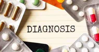 Beyaz arkaplanda Diagnozis 'e mesaj at. Yakınlarda çeşitli ilaçlar var. Tıbbi konsept.