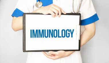 Doktor içinde IMMUNOLOGY tıp konsepti olan bir kart tutuyor.