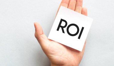 Pembe gömlekli bir iş adamının elinde kağıt kartvizit var. Beyaz arka planda izole edilmiş ROI keskinliğinde, yakın plan.