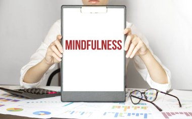 İş kadınının elinde içinde MINDFULNESS yazan bir kart var