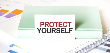 Beyaz büyük not defteri, yeşil kitap ve kâğıt sayfası üzerinde mali diyagram ve metin PROTECT kendin. İş konsepti