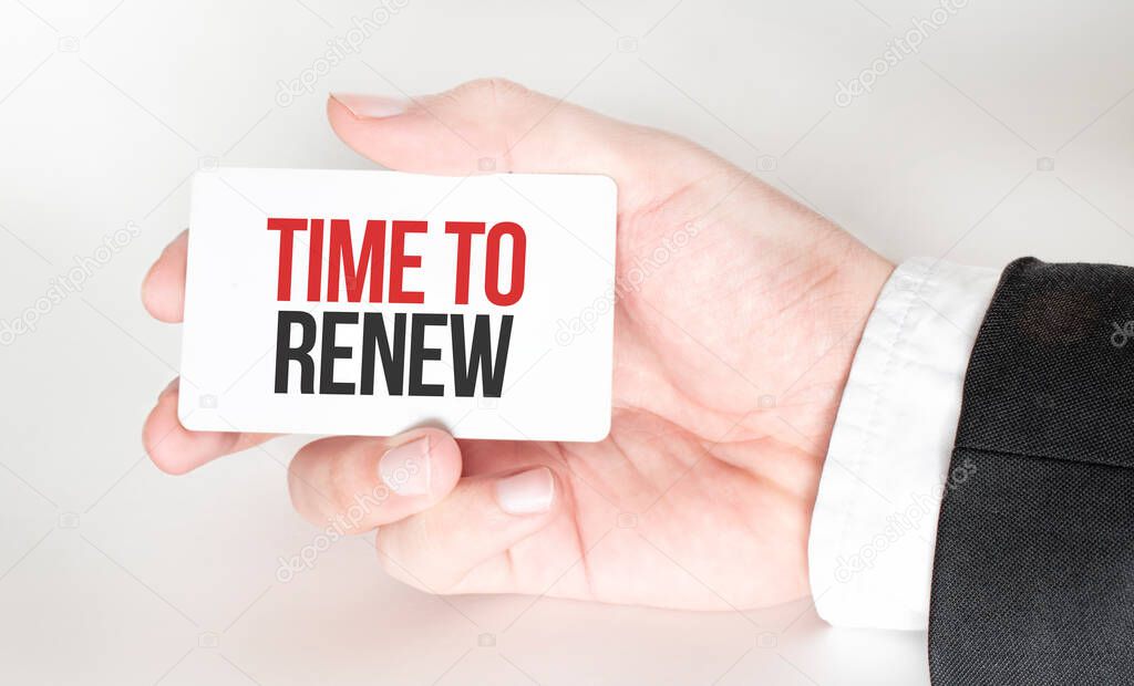 businessman holding a card with text TIME TO RENEW