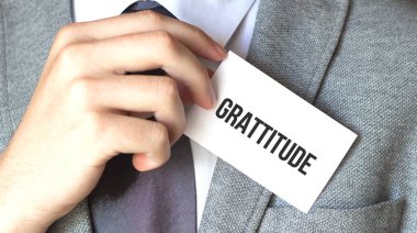 Bir iş adamı elinde metin grafiği olan bir kart tutuyor.