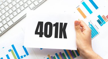 İş adamı elinde 401k yazılı bir kart tutuyor. Klavye, diyagram ve beyaz arkaplan