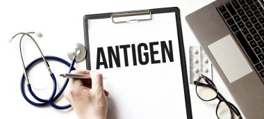 Doktor elinde ANTIGEN yazılı bir kart tutuyor, tıbbi konsept.