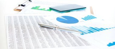 Finansal değerleri olan kağıt tabaka, yeşil diyagram ve telefon beyaz masanın üstünde..