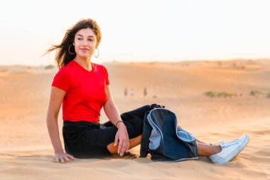 Sırt çantalı güzel bir kız fantastik bir manzarada dinleniyor. 