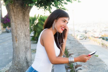 Güzel bir kız, İtalya 'daki karantinadan çıkmış ortağıyla konuşurken akıllı telefonuna gülümsüyor.