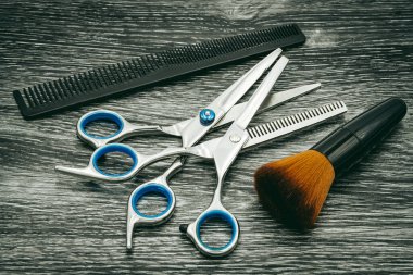 Fırça ve tarak ile çeşitli kuaför makasları, kuaförler ve kuaförler için ideal fotoğraf, koyu ahşap arka plan