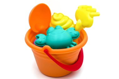 Plaj oyuncakları: beyaz arka planda izole edilmiş kürek ve sarı tırmıkla çocuk portakal kovası