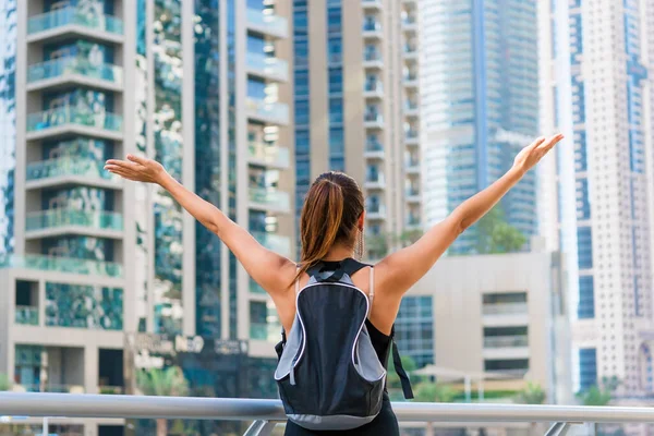 Birleşik Arap Emirlikleri 'ndeki Dubai marinasında siyah elbisesiyle tanınmayan mutlu güzel turist kadın. BAE 'de lüks ve konforlu turizm sezonu.