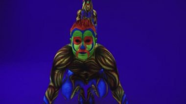 Neon kostümlü akrobatik ikizler kafalarında ve ellerinde, ultraviyole makyajlı mavi siklonamada bir duruş sergileyecekler. Parlak floresan vücut sanatı karanlıkta parlar..