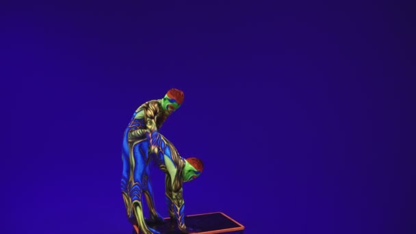 Acrobatische Tweeling Neon Kostuums Een Stand Handen Het Hoofd Uit — Stockvideo