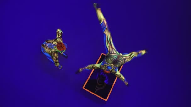 Akrobatická Dvojčata Neonovém Kostýmu Předvádějí Stojan Rukou Hlavě Modrém Cyklorámu — Stock video