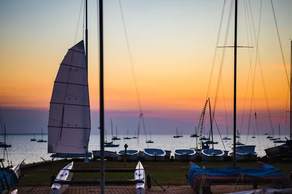 Łodzie żaglowe zaparkowane na przyczepach nad morzem o zachodzie słońca — Zdjęcie stockowe