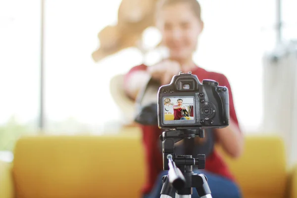 Güzel Asyalı kadın blogcu internet sitesinde ayakkabı sattığı için video DSR Kamerada kayıt yapıyor. Sosyal medya konseptinde pazarlama. Kapalı kameraya odaklanma.
