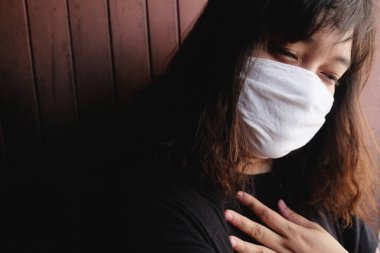 Tayland 'da Covid-19 veya Corona virüsünü ve Hava Kirliliği Değeri Pm 2.5' i önlemek için beyaz bez bir maske takan Asyalı kadın. Solunum sisteminde havasızlıktan boğuluyor. Sağlık ve hastalık konsepti