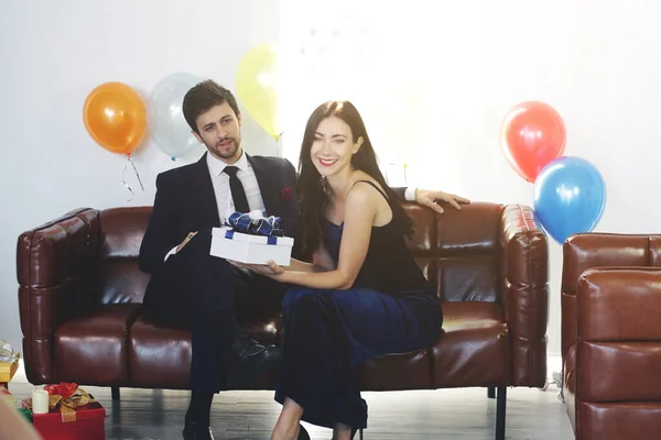 Sweet couple Love happy with surprise gift box girlfriend in christmas party, Birthday time celebration new year eve, Valentine day decoration with colorful balloon on brown sofa in living room