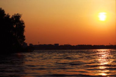 Tayland 'da kargo gemisi ve teknesiyle nehirde güzel bir gün batımı.