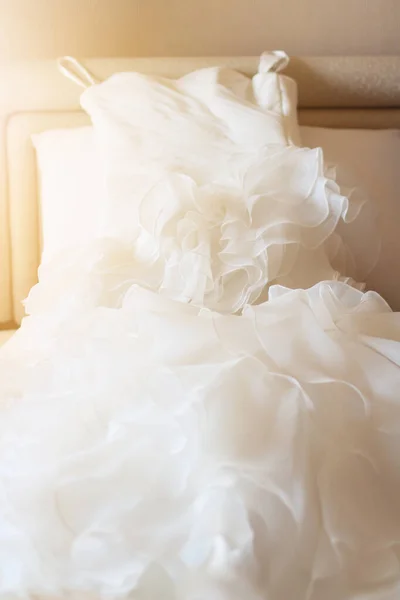 ホテルの部屋で美しい太陽の光と白いベッドの上のウェディングドレス バレンタインデーとお祝いのコンセプトへの愛 — ストック写真