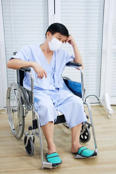 Asian Old man Wearing a mask to prevent disease and Covid 19 is sitting on wheelchair Sick and seriously ill in Hospital. Healthcare and Elderly society Concept