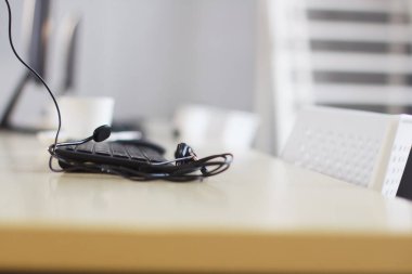 Kulaklık ve klavyeli bilgisayar, Çağrı Merkezi 'nin çalışma alanındaki ahşap masa üzerinde ve modern ofiste tele-pazarlama işi. Teknoloji konsepti