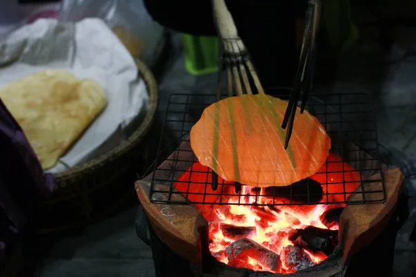ndigenous rice cracker on stove on street food night market at Thailand