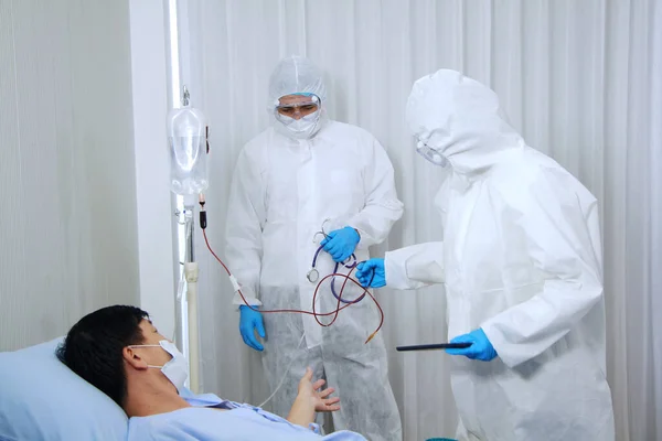 Kişisel Koruyucu Ekip ya da PPE giysileri. Covid 19 virüsü kapmış Taylandlı yaşlı bir hastaya kan ve şifa vermek için acele edin..