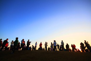 NAN, THAILAND-ARALIK 13 ARALIK 2015: Altın güneş ışığı altındaki güzel insanların silueti gökyüzünde parlıyor ve alacakaranlık dağda gün doğumuyla birlikte