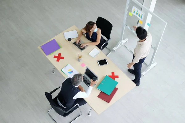 Asian team and Caucasian boss is businesspeople teamwork wearing mask for preventing covid19 virus and brainstorming in meeting room at office. Healthcare and New normal lifestyle in business concept.