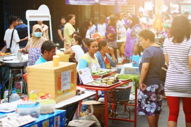 UTHAI THANI, THAILAND - 19 Mart 2016: Tayland 'ın kırsal kesimindeki gece pazarında elde yapılan yerel sokak yemekleri ve hediyelik eşyalar