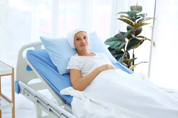 白いスカーフを着た白人のお母さんは 癌や白血病の患者に苦しんでいるので 化学療法後に病院のベッドに横たわっています — ストック写真