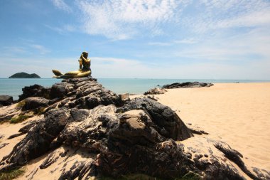 SONGKHLA, THAILAND - 09 Mayıs 2012: Tayland 'da Samila plajında güneş ışığıyla kayadaki Denizkızı heykeli