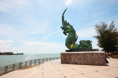 SONGKHLA, THAILAND -09 Mayıs 2012: Tayland 'da Samila plajında yeşil Naga (Phaya Nak) heykeli güneş ışığıyla su püskürtüyor