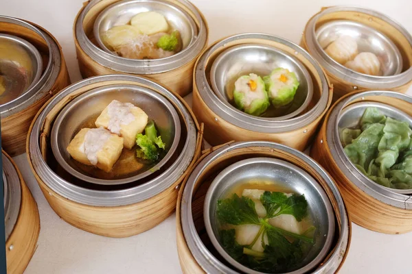 Traditional steamed chinese food Dim Sum and dumplings served preparation in bamboo basket