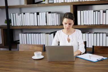Kafkasyalı kadın kafeteryadaki atölyede dizüstü bilgisayarla çalışıyor. O, üniversitede ya da ofiste kütüphanede eğitim araştırması yapıyor. Teknoloji konseptine sahip iş kadınlarının yaşam tarzı