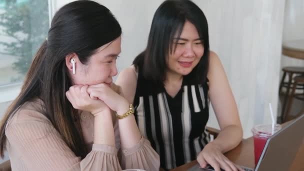 笑着的一对亚洲女人是友情的同事 也是笔记本电脑社交媒体平台上的网上购物对象 与女商人合作的技术 — 图库视频影像