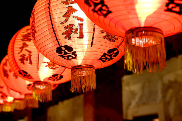 Close up beautiful red Chinese paper lantern with Chinese characters hanging on Chinese New Year holiday in night scene