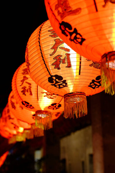 Close up beautiful red Chinese paper lantern with Chinese characters hanging on Chinese New Year holiday in night scene