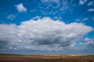 Parlak bulutlu bir gökyüzü. Güneşli noktalar.
