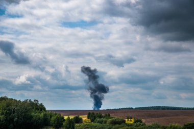 Şehirde yangın var. Gökyüzüne yükselen siyah bir duman sütunu.
