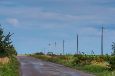 Kırsal yol elektrik direklerinden geçiyor.