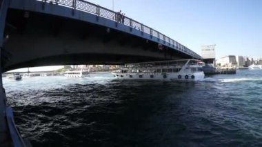 İstanbul. Hindi. 7 Haziran 2019; İstanbul limanındaki bir köprünün altından beyaz bir zevk gemisi geçiyor.